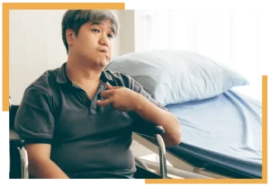 Man in a wheelchair beside a hospital bed