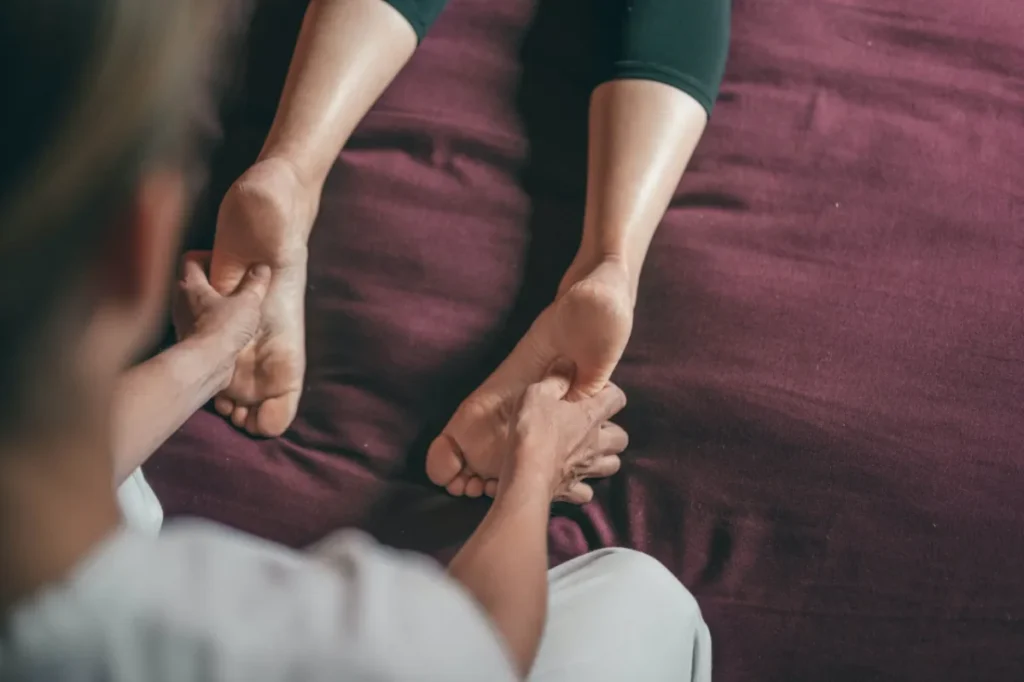 Therapist holding a patient’s feet during treatment