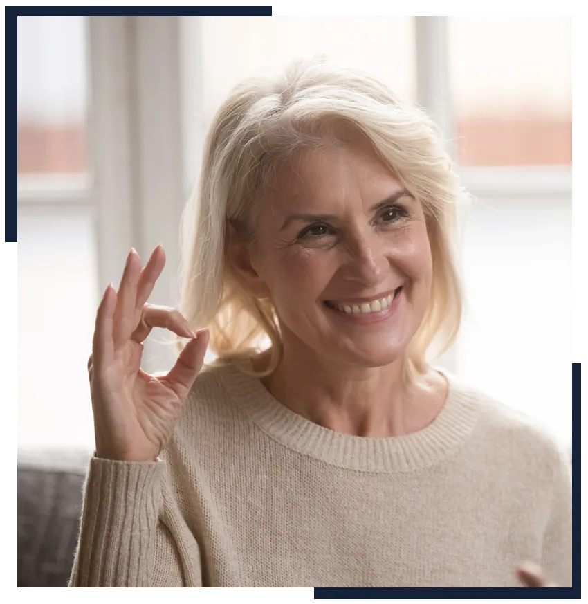 Smiling older woman giving an OK sign