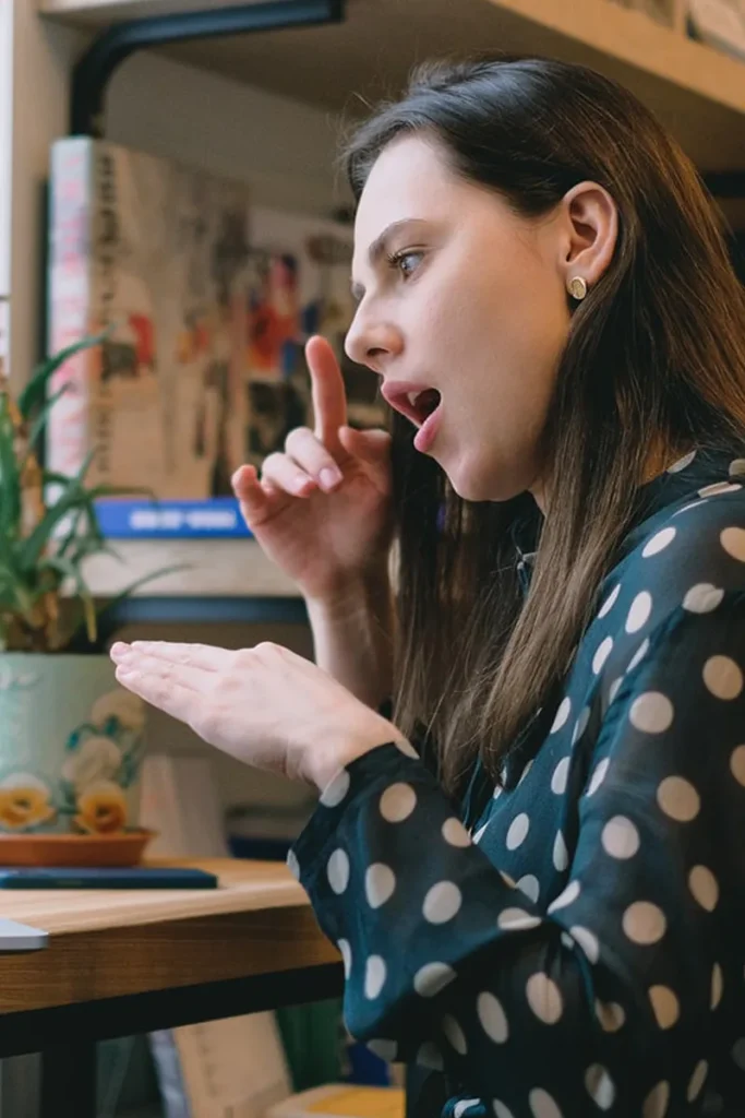Woman practicing speech sounds with her hand at her mouth
